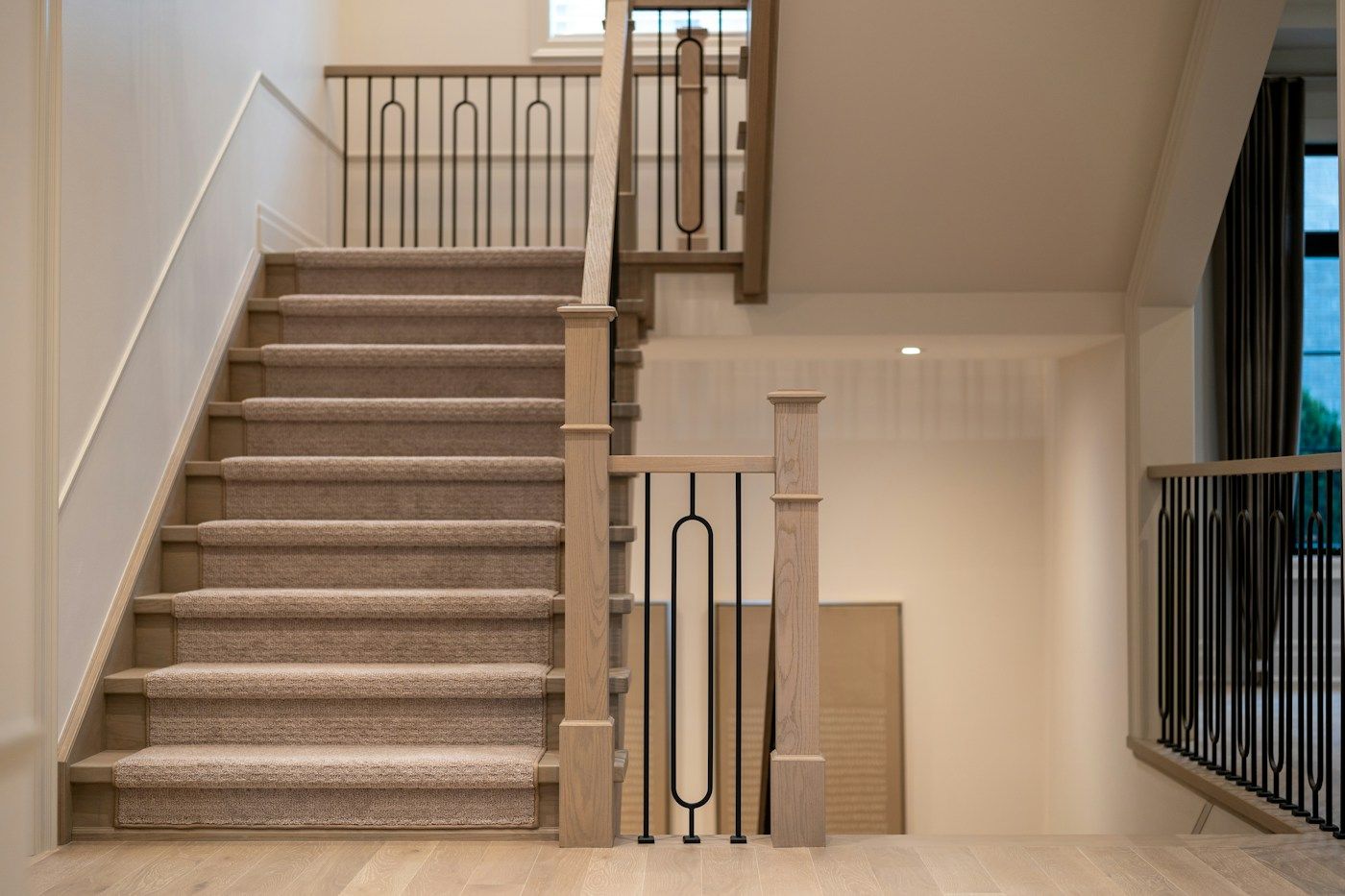 Escalier intérieur moquetté avec une rampe en bois et une main courante